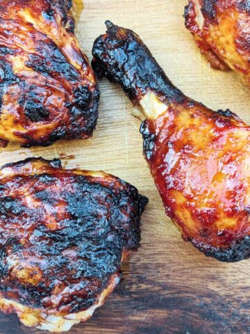 Air fryer bbq chicken wings and thighs, cooked and presented on a wooden board
