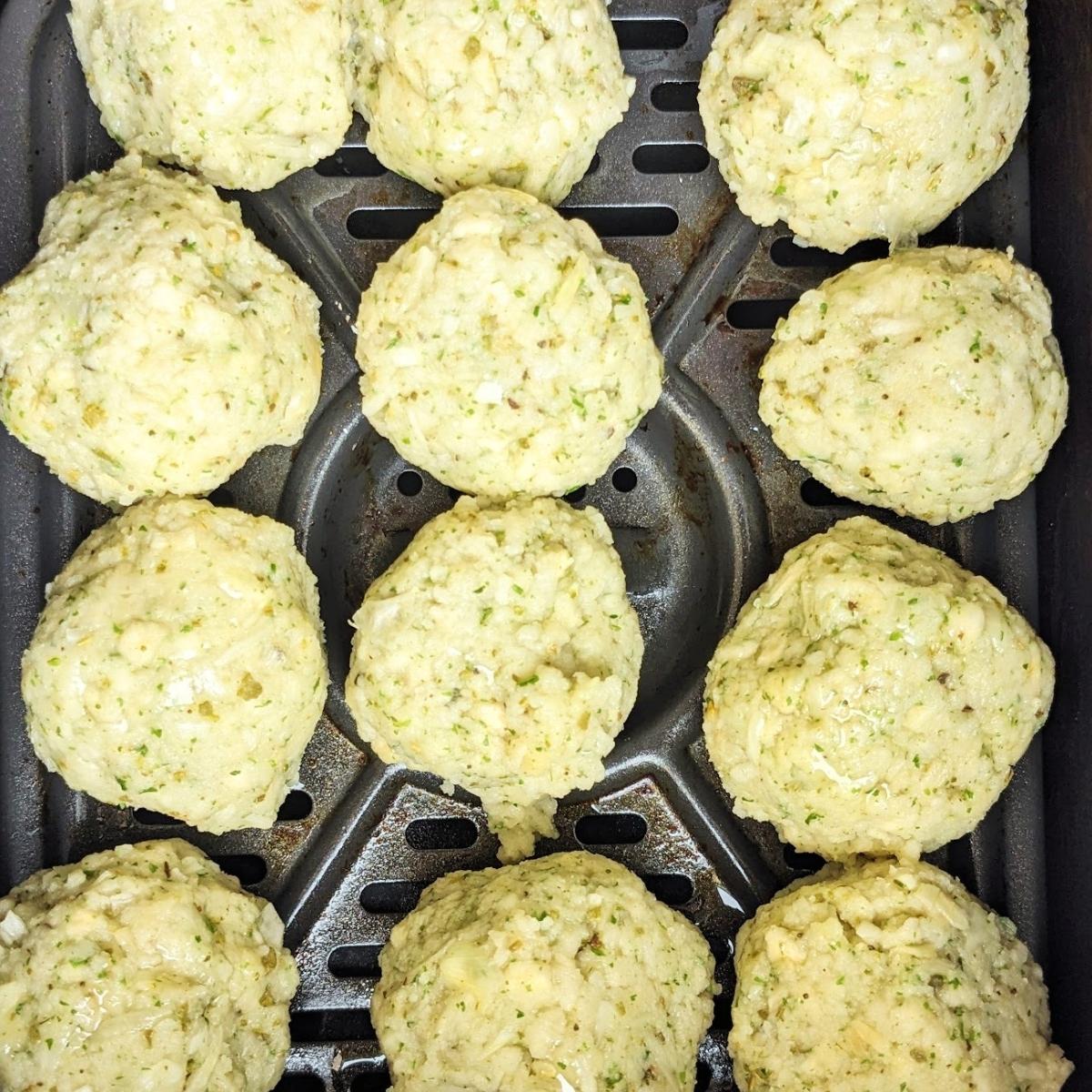 Stuffing balls lined up in an air fryer basket.