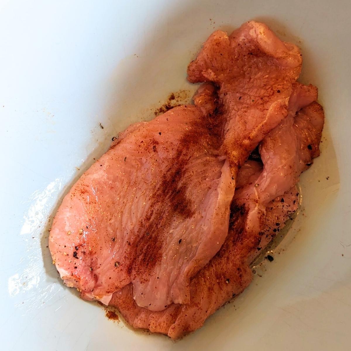 Raw turkey breast steaks in a bowl.