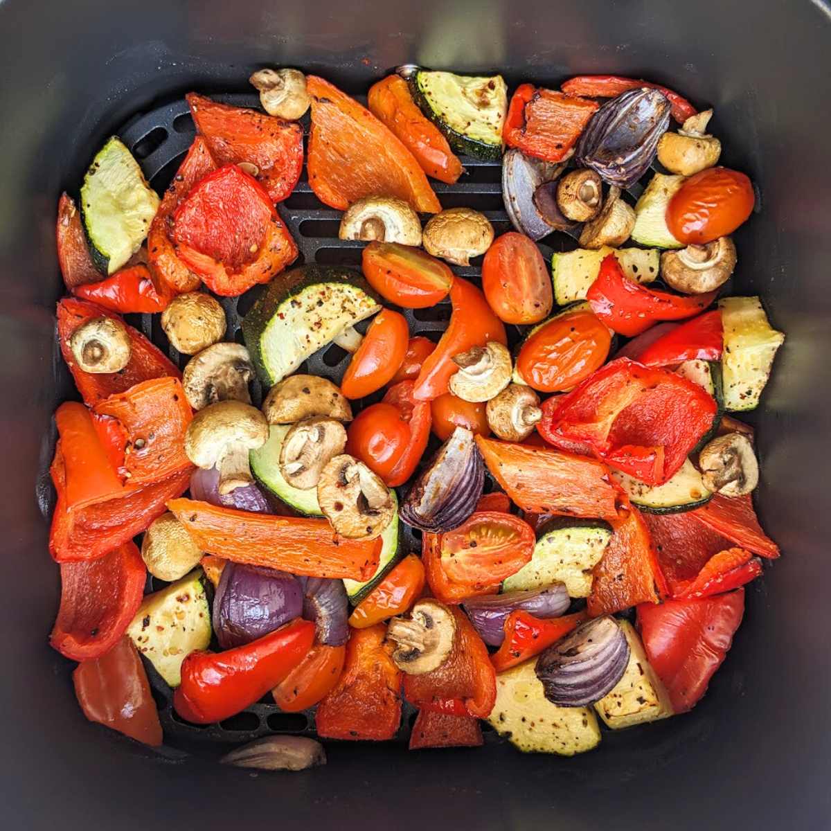 Roasted vegetables in air fryer basket.